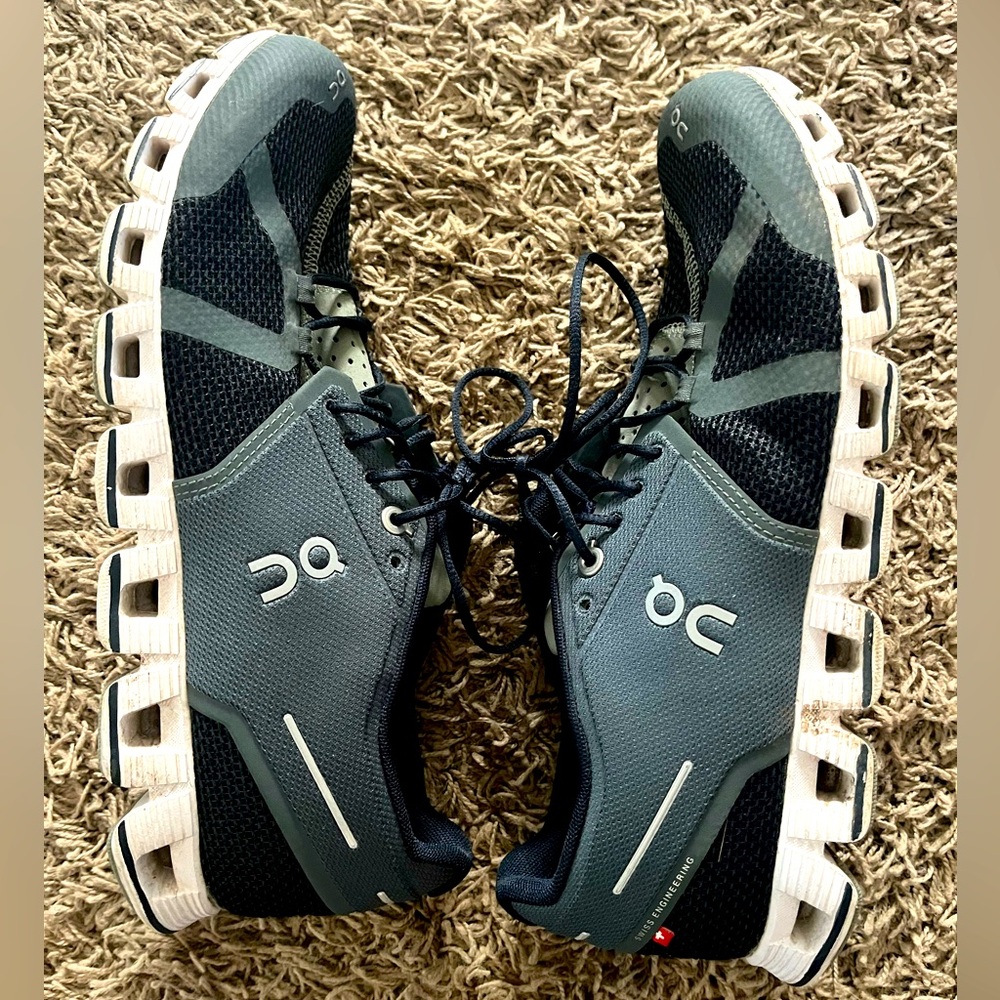 On cloud black and gray tennis shoe.